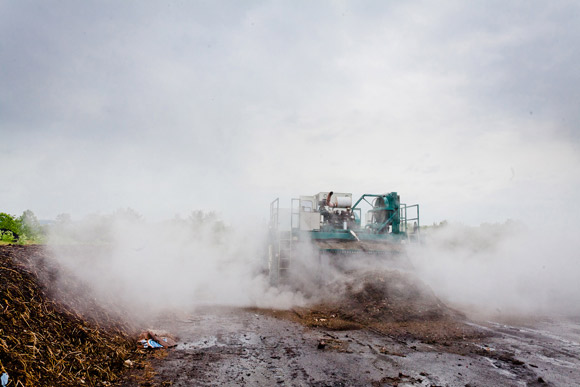 Steam billows from wind rows of compost as they are turned and areated.