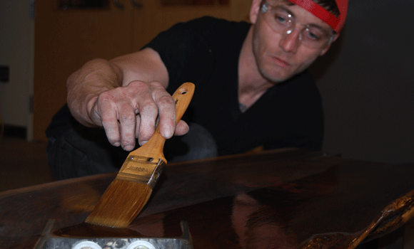 Matukaitis adds a coat of varnish to his latest wood and steel furniture creation.